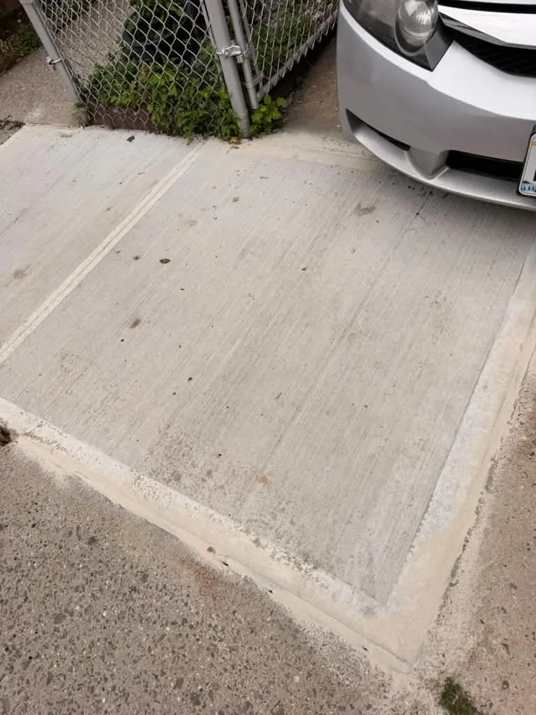 Rebuilt concrete sidewalk slabs beside a driveway entrance on Matthews Ave in the Bronx