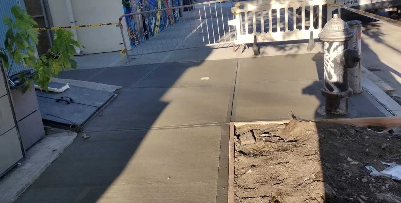 New concrete sidewalk in front of a multifamily building on Hutchinson River Pkwy E in the Bronx